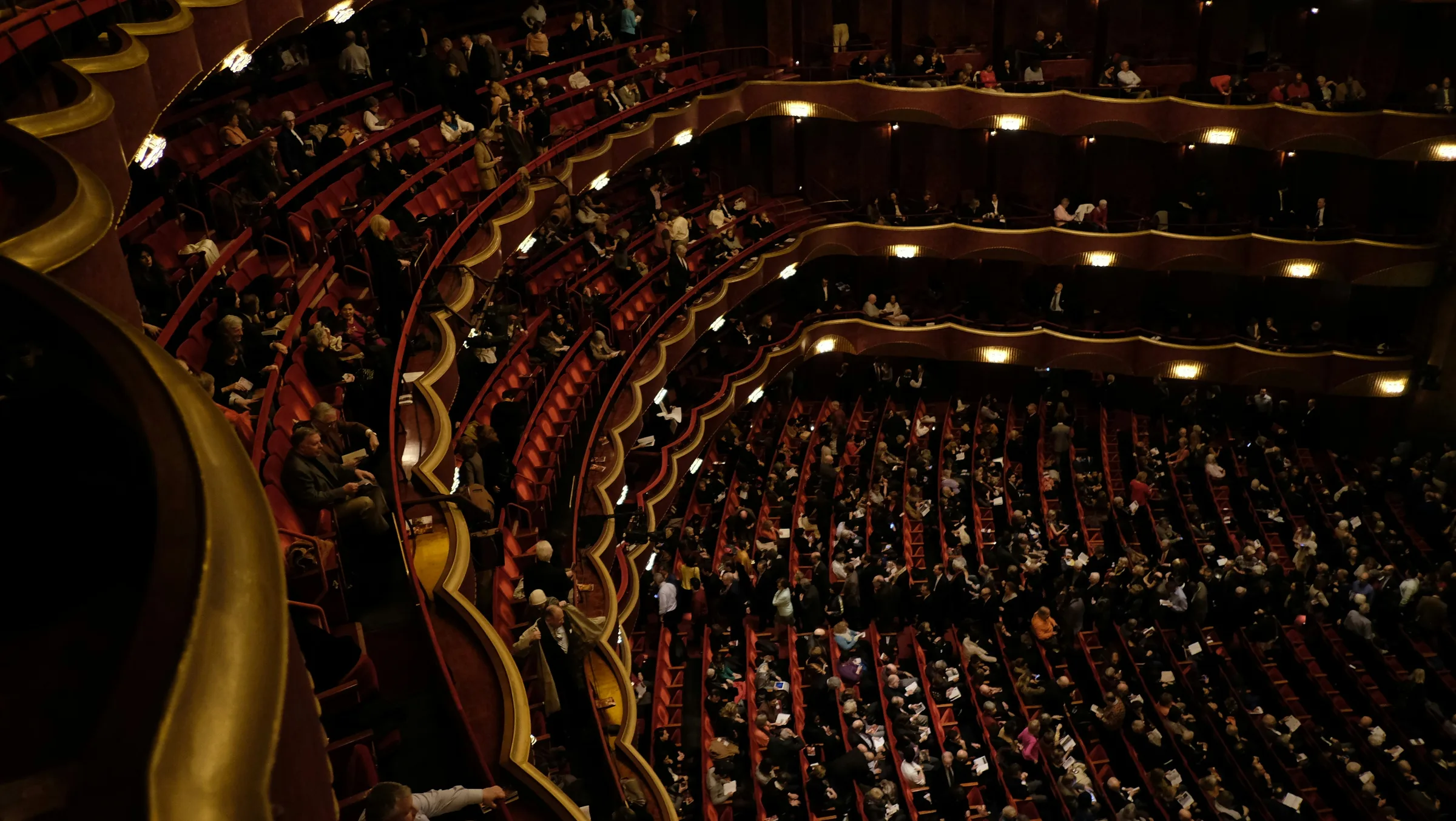 Concert hall with red velvet seating and a full audience